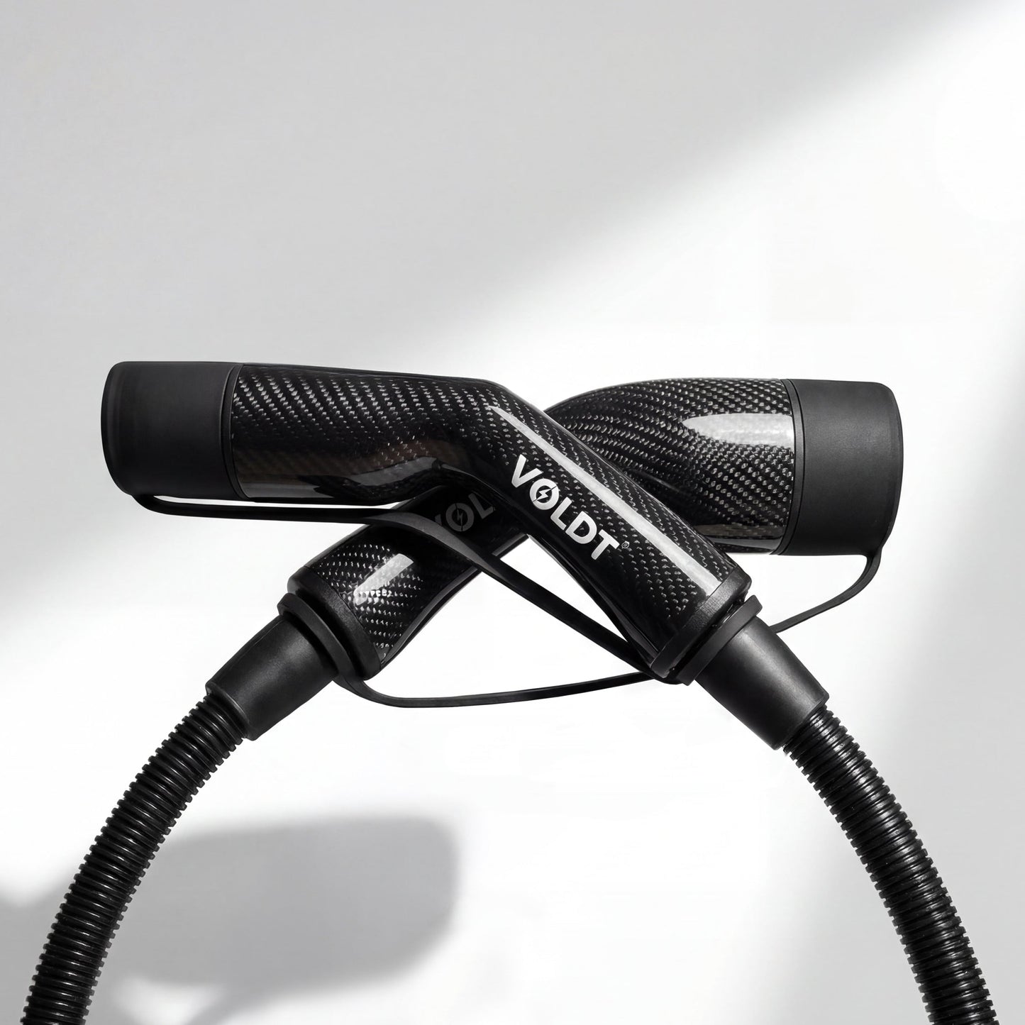 Stijlvol elektrisch laden met de lichtgewicht Voldt carbon fibre laadkabel bij een sportauto.